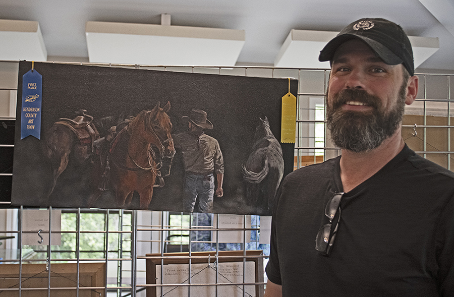 Photo of People's Choice winner for artwork Ryan Richey standing next to his painting.